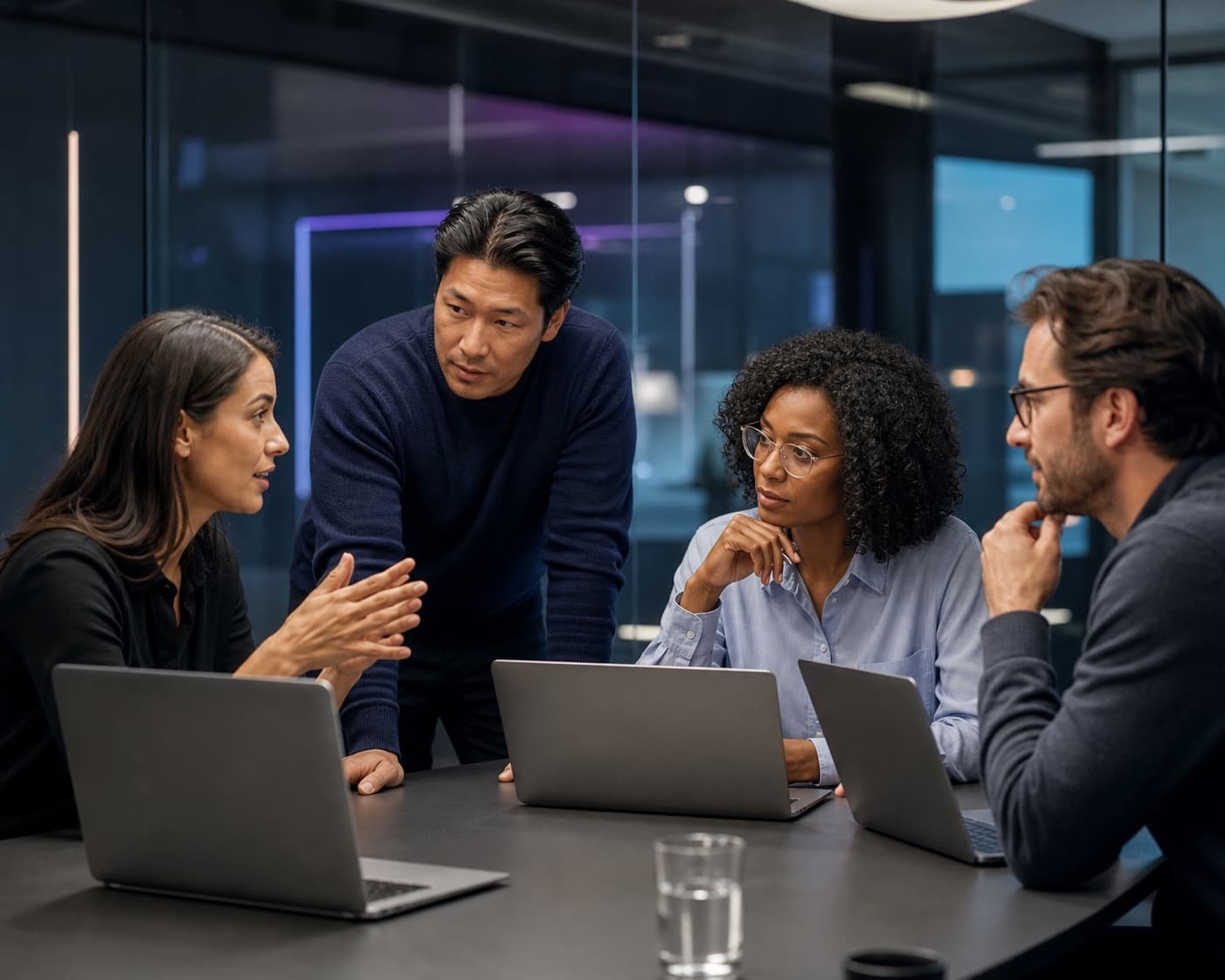 Illustrative scene of four people collaborating around laptops in an office