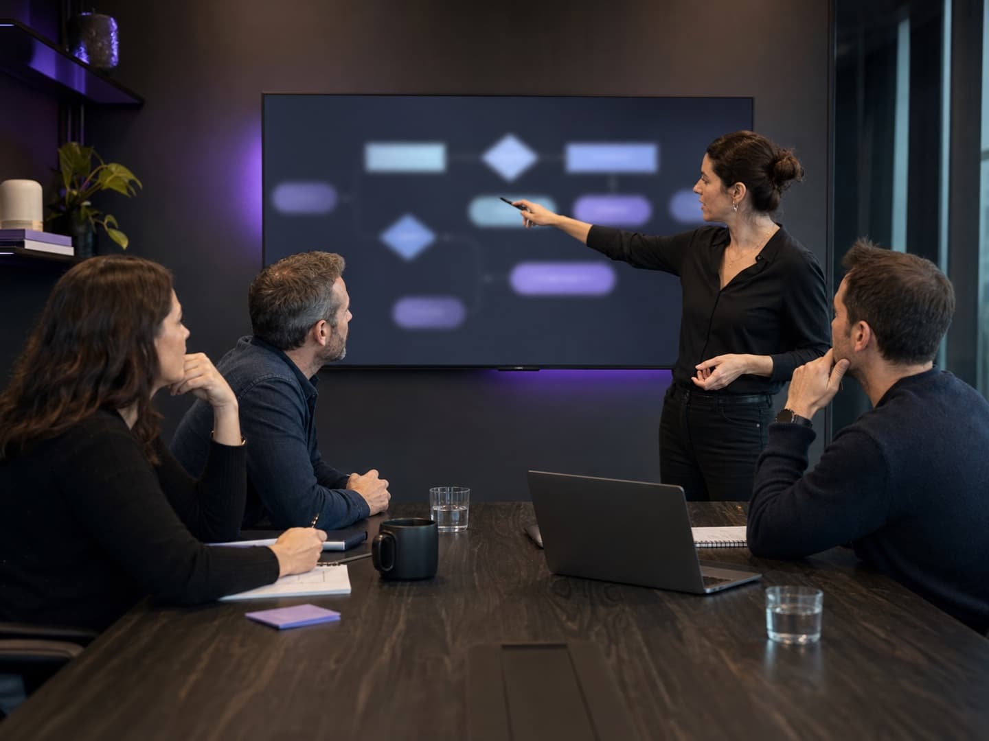 Illustrative demo session with a facilitator and three participants mapping an abstract workflow in an unbranded meeting room