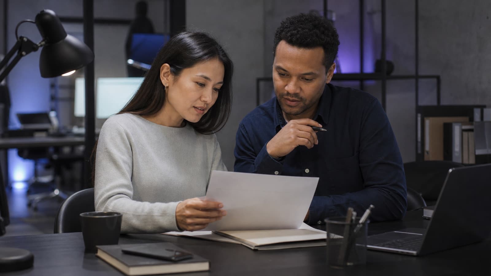 Illustrative financial services scene of two analysts reviewing an unbranded document
